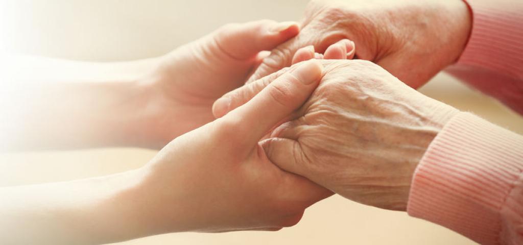 Palliatieve zorg - Helpende handen nemen handen bejaarde persoon vast